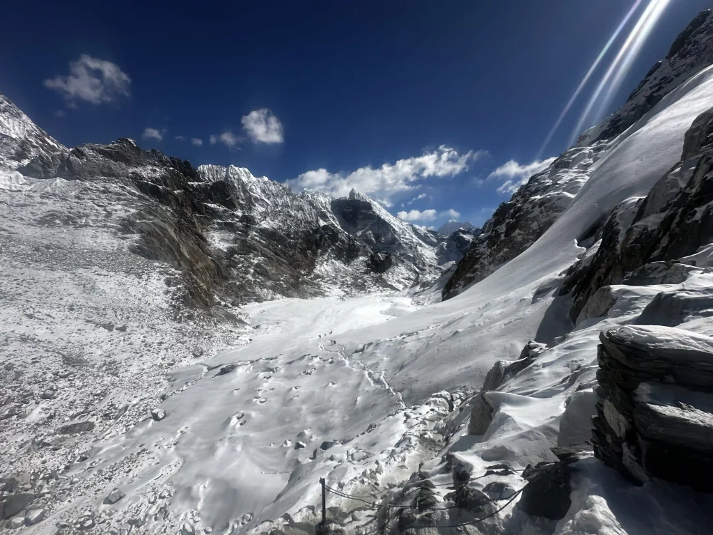 Snow-covered mountain pass on the Everest Three High Passes Trek, with dramatic Himalayan peaks under clear blue skies.