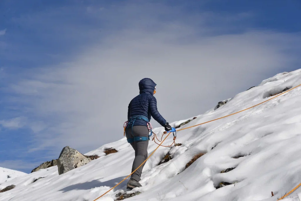 Solo climber making their way through snow-covered terrain during Yala Peak Climbing in Nepal’s Langtang region, with towering mountains in the background.